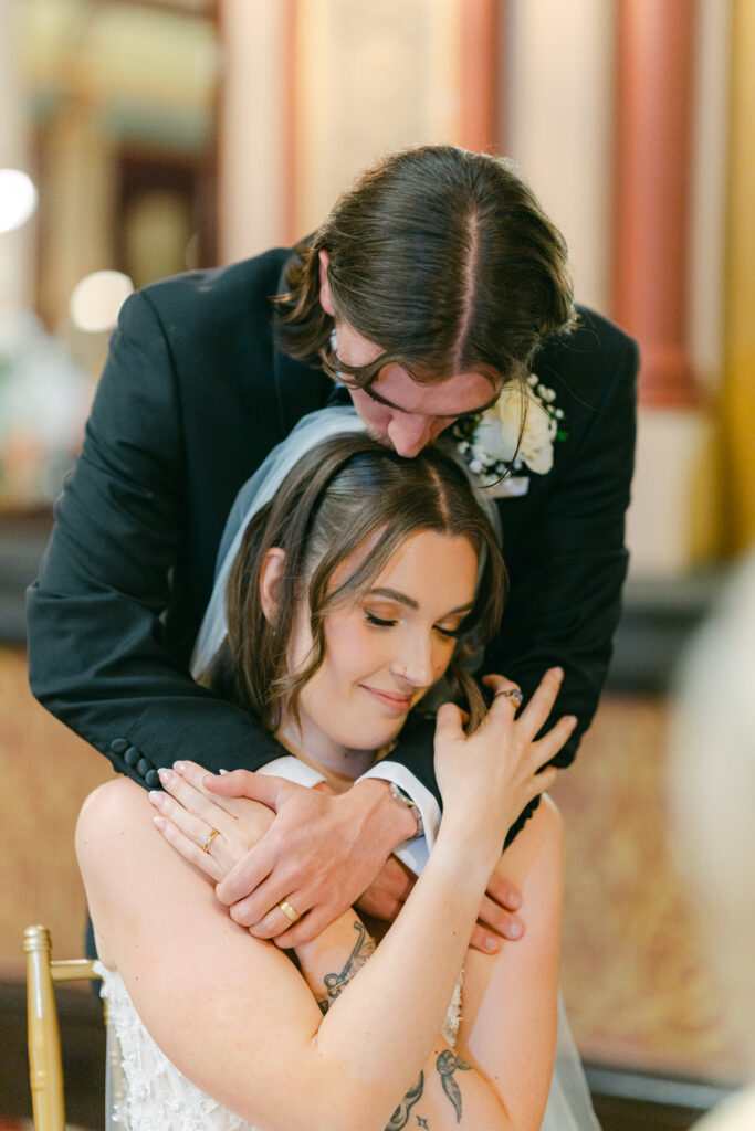 Groom kissing bride on the head